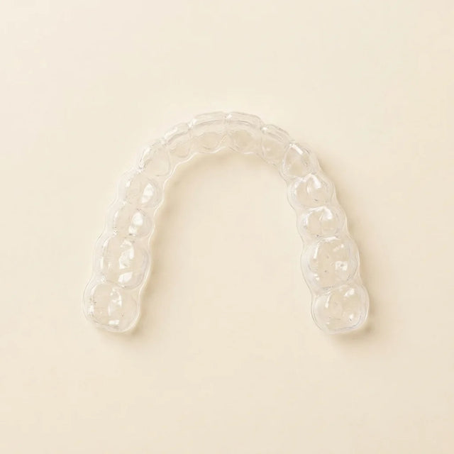 Clear aligner on a clean surface, viewed from above